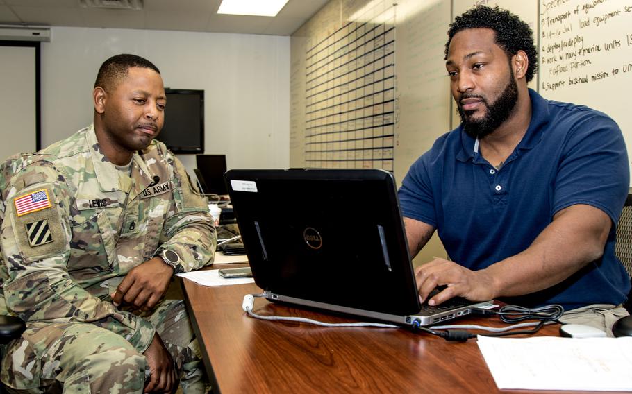 U.S. Army Staff Sgt. Christopher D. Lewis, left, reviews his life insurance policy during a 2017 event in Tampa, Fla. In March, members will see the first Servicemembers’ Group Life Insurance coverage increase, from $400,000 to $500,000, since 2005.