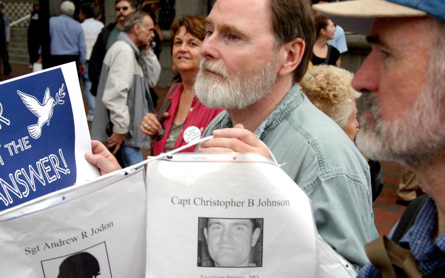 An anti-war protester marches past the White House, helping to carry a stream of photos on a string of servicemembers killed in Iraq and Afghanistan.