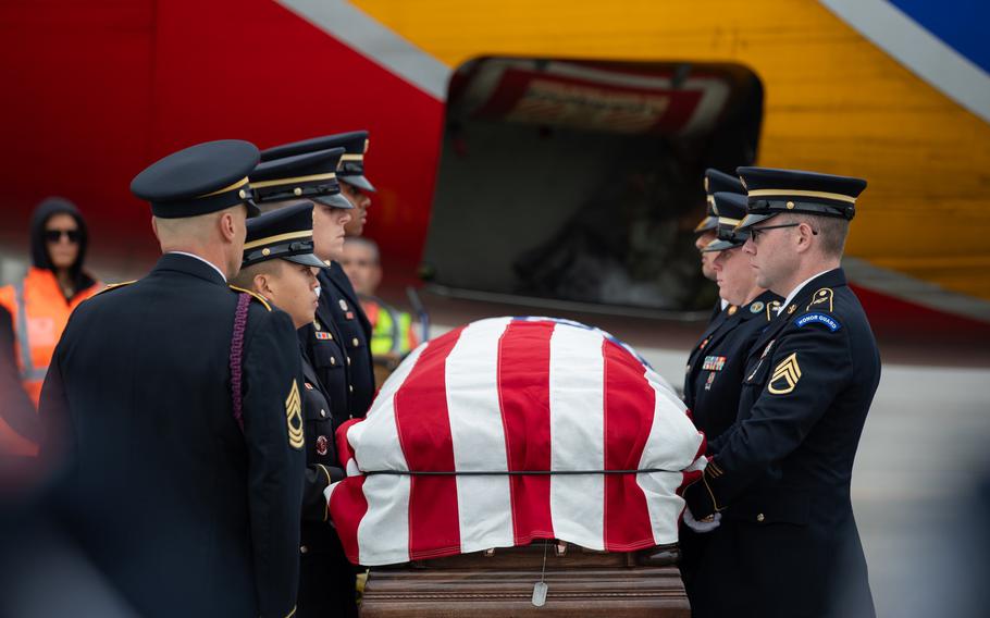 A casket being escorted onto a plane