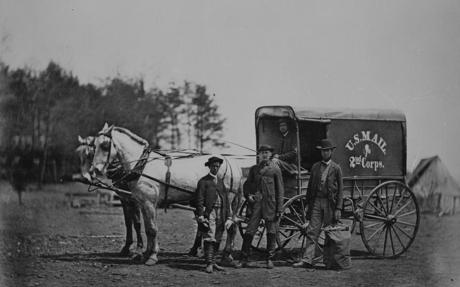 Men stand in front of a wagon.