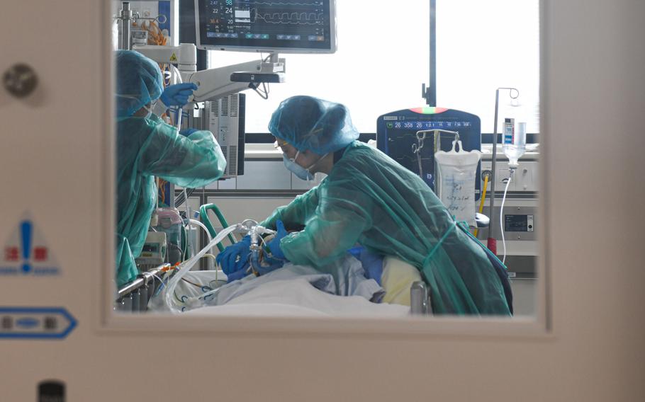 Health care workers treat a COVID-19 patient inside the ICU at Chiba University Hospital on Aug. 25, 2021.