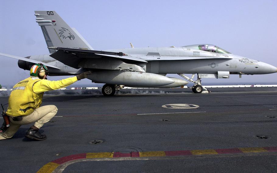A flight deck “shooter” signals as an F-18 Hornet from VFA-195 is launched from the USS Kitty Hawk’s flight deck Monday, April 15, 2002.
