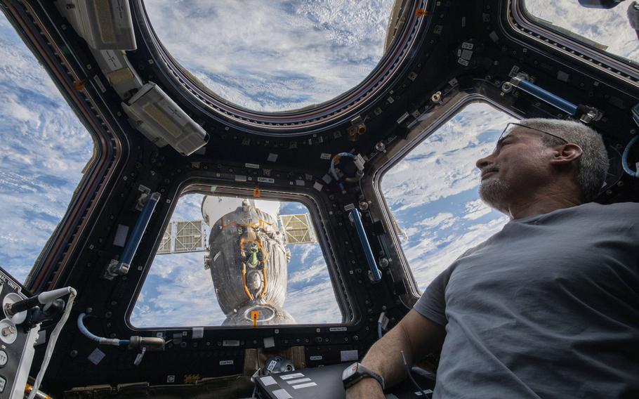 In this photo provided by NASA, U.S. astronaut and Expedition 66 Flight Engineer Mark Vande Hei peers at the Earth below from inside the seven-windowed cupola, the International Space Station’s window to the world on Feb. 4, 2022.