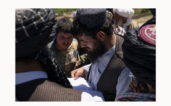 Community members gather around Wakil Ahmad Nayabi, trying to get help as he goes down a list of those who lost their homes, crops, and livestock in a flood zone in Chesht-e-Sharif on May 10, 2024.