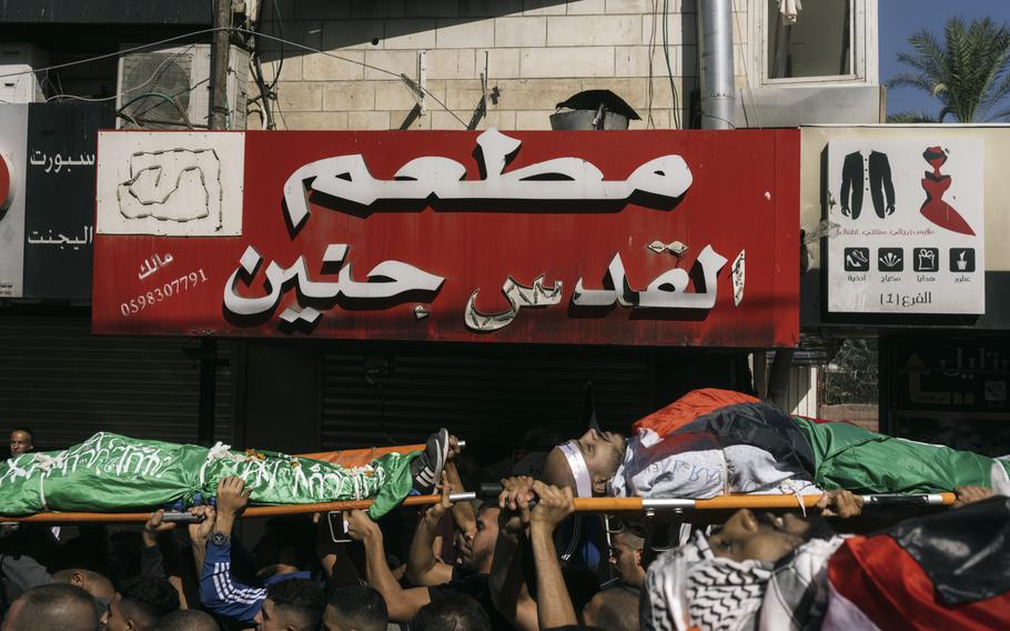 Bodies are carried during a funeral for several militants on Friday, Nov. 10, 2023, in the Jenin refugee camp in the West bank.