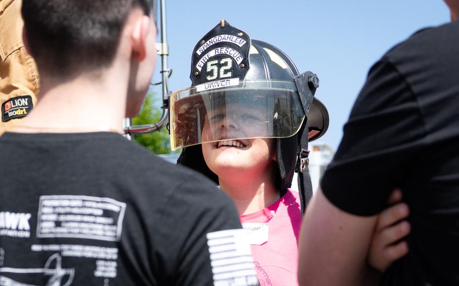 A child wears a helmet reading “Spangdahlem Fire Rescue Driver.”