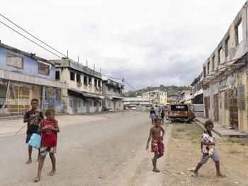 Children traverse riot-scarred Chinatown on their way to fish in Honiara. Some structures in the area remain in ruins, with rebuilding hampered by fears of fresh violence. 