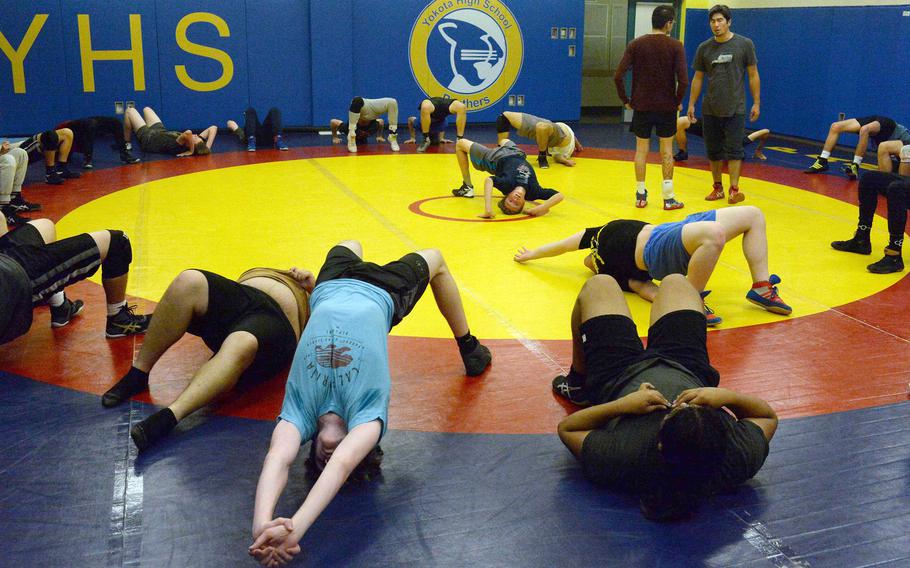 Yokota's wrestlers practice back bridges during practice. The Panthers have 32 wrestlers in the practice room this fall.