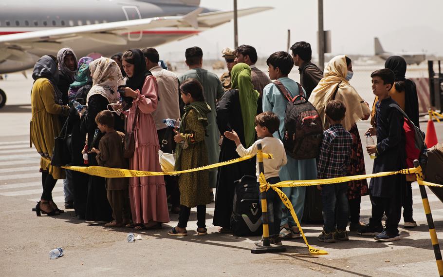 Civilians prepare to board a plane during an evacuation at Hamid Karzai International Airport, Kabul, Afghanistan, Aug. 18, 2021. U.S. Marines are assisting with the evacuation of people from Afghanistan following the Taliban's takeover.