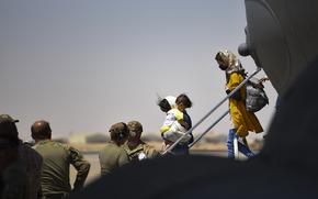 Afghan evacuees exit an airplane.