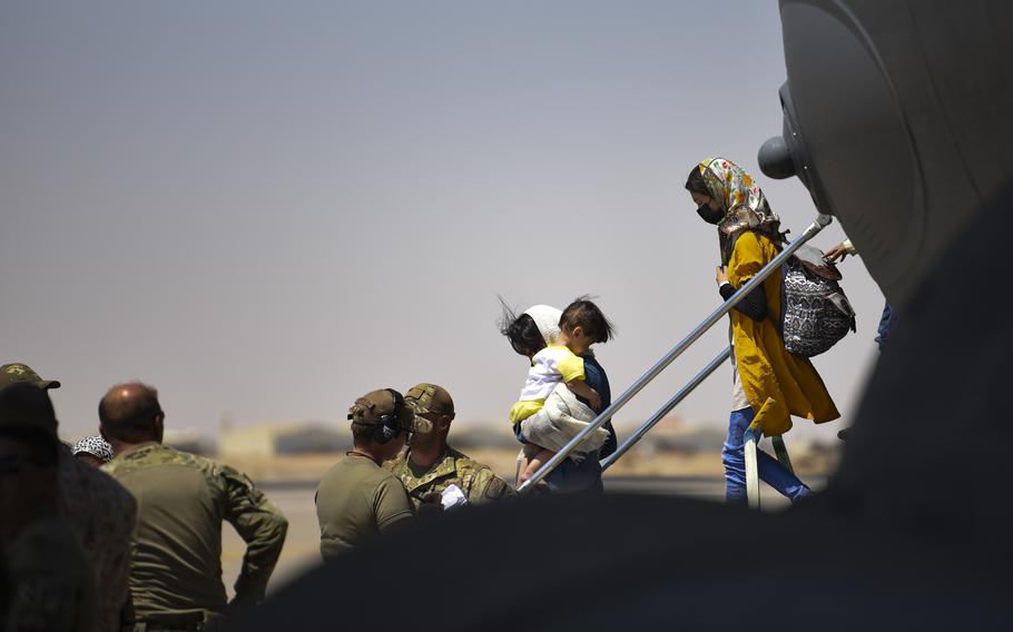 Afghan evacuees exit an airplane.