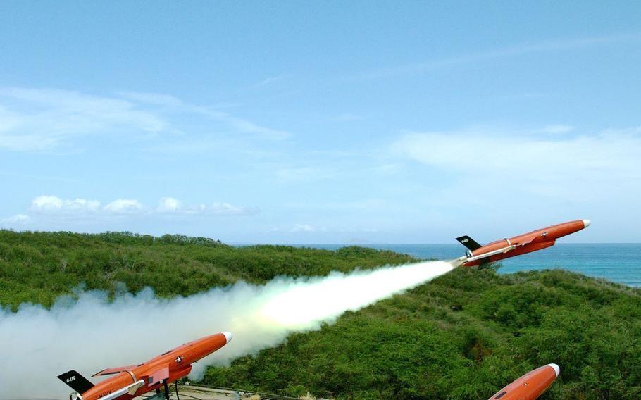 Three red drones are launched into the sky.