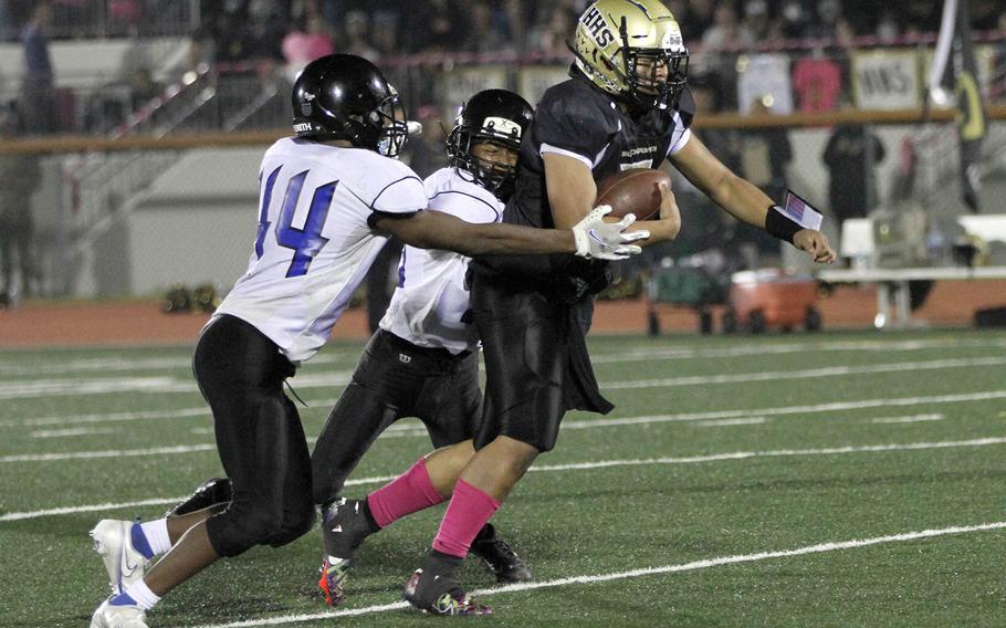 Humphreys quarterback Sean Cook is wrapped up by Osan's Dylan Watson and Justiss Parker Jones. Cook accounted for 220 yards total offense and threw two touchdown passes in the Blackhawks' 29-6 win.