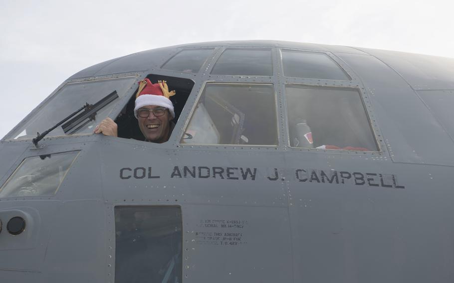 Col. Andrew Campbell, 374th Airlift Wing commander, smiles from the cockpit of a C-130J Super Hercules during Operation Christmas Drop, now in its 70th year, on Guam, Dec. 5, 2021. 