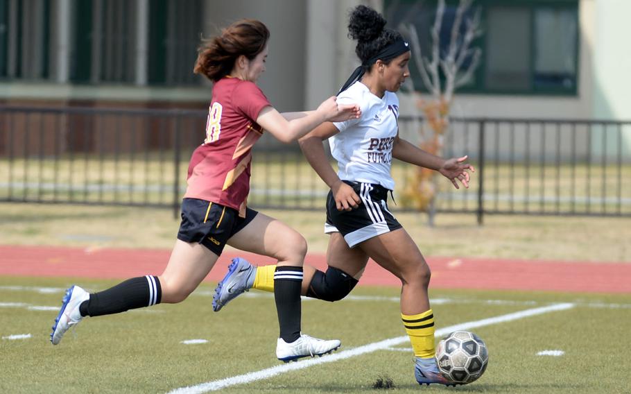 Matthew C. Perry's Ivanelis Nieves-Bermudez races upfield with the ball past Marist Brothers International's Riko Noda during Friday's Western Japan Athletic Association girls soccer tournament. The teams played to a 2-2 draw.