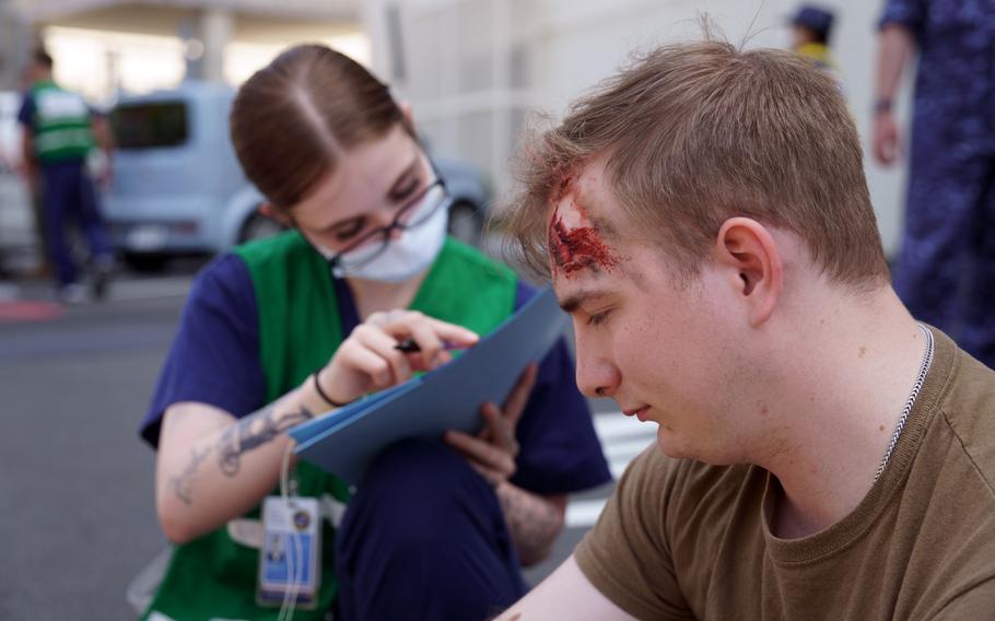 An actor taking part in an earthquake-response drill goes through triage at Yokosuka Naval Base, Japan, Wednesday, May 17, 2023.
