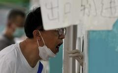 A resident gets his routine throat swabs at a COVID-19 testing site in Beijing, Sunday, Aug. 7, 2022. (AP Photo/Andy Wong)