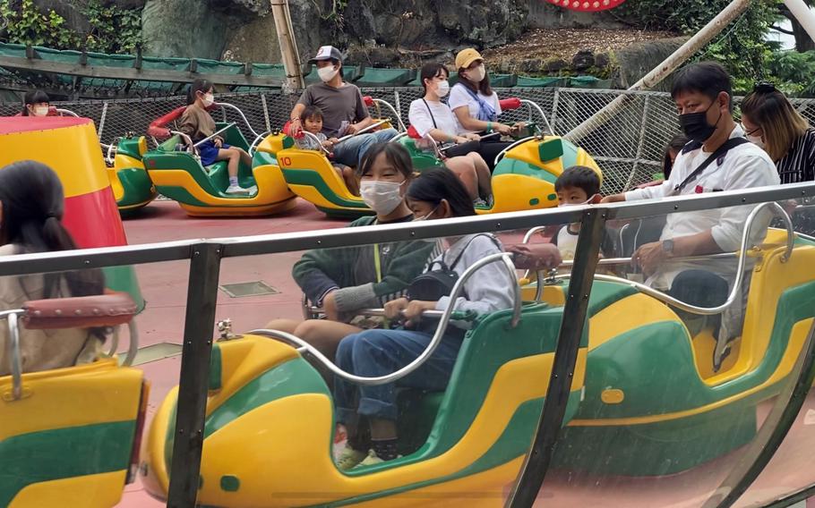 Fun-seekers wear masks on a ride at the historic Hanayashiki amusement park in Asakusa, Tokyo, Saturday, Oct. 16, 2021.