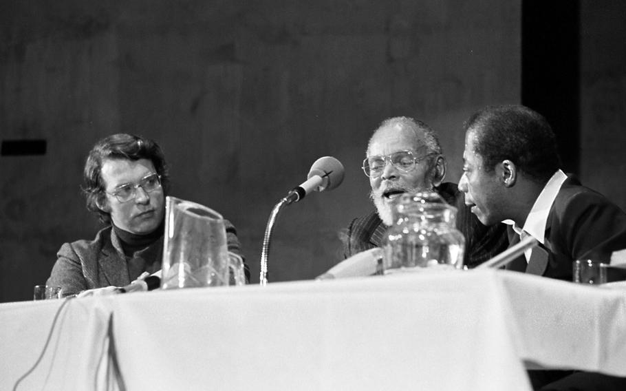 Moderator Gary Stevens listens as authors Chester Himes and James Baldwin talk. 