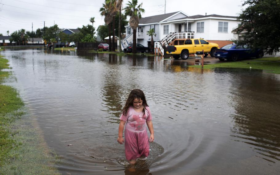 A girl wades through floodwaters after Hurricane Nicholas landed in Galveston, Texas, on Sept. 14. A new NASA Earth science mission will use satellite observations to investigate such storms.