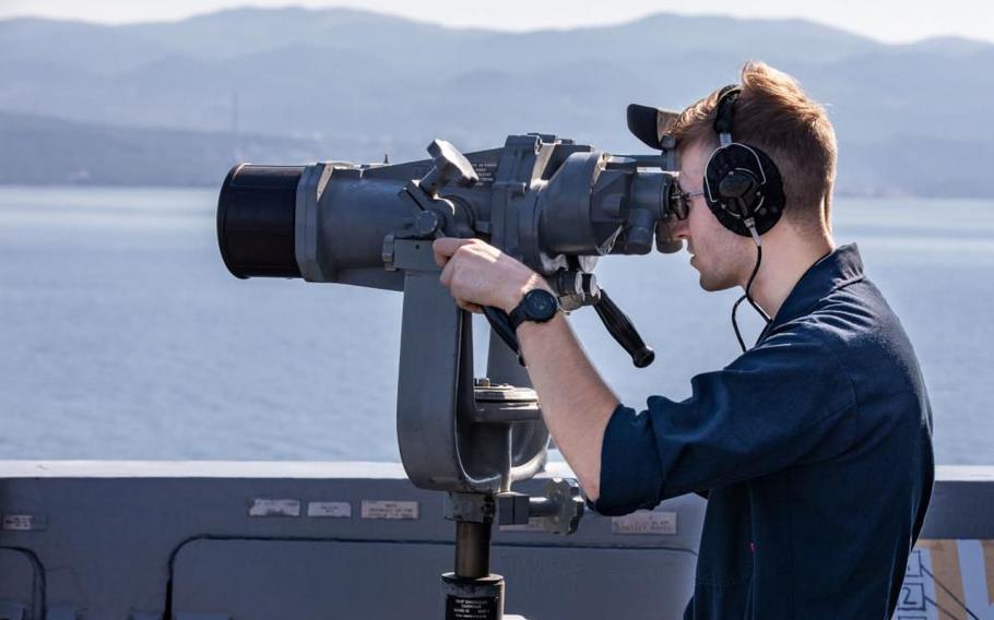 Seaman Joshua Morgan, a cook on USS Arlington, stands lookout watch as his ship arrives in Rijeka, Croatia for mid-deployment voyage repairs, July 4, 2022.