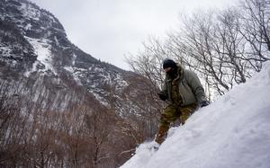 A student at the U.S. Army Mountain Warfare Schools advanced military mountaineer course uses a locator beacon to find a simulated casualty during avalanche rescue training in January 2022. The Army recently established the Mountaineering Badge, which active-duty soldiers will be able to wear for the first time upon graduating from the basic mountaineering course.