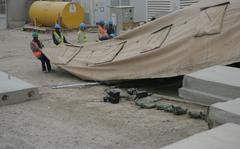Kellogg, Brown & Root subcontractors tear down the outer lining of a transient tent aboard Camp Fallujah, Iraq, Nov. 20, 2008. KBR agreed to settle a federal lawsuit alleging that its employees took kickbacks while performing work for U.S. forces in the Middle East, the Justice Department said on June 14, 2022.  