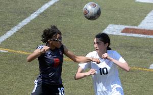 Nile C. Kinnick's Jaylah Petty and E.J. King's Joanna Hall try to head the ball during Saturday's DODEA-Japan girls soccer match. The Red Devils won 2-0.