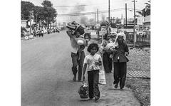 John Olson/Stars and Stripes
South Vietnam, May, 1968: Refugees flee gunfire and burning buildings near Tan Son Nhut air base, on the outskirts of Saigon. South Vietnamese authorities said at noon on May 9 that about 46,000 people had taken refuge in central Saigon since the beginning of a Viet Cong offensive five days earlier; they estimated that another 14,000 would arrive by nightfall.