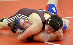Ramstein’s Evan Brooks, left, was able to get out of the grip of Vilseck’s Isaac Lane and go on to win the 190-pound match on opening day of the high school 2022 Wrestling Tournament in Kaiserslautern.
