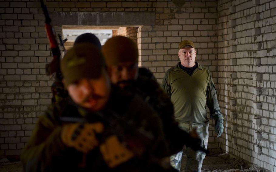 Patrick Creed, a retired U.S. Army major, evaluates members of the Ukrainian Territorial Defense Forces as they rush through the hallway of an abandoned building and clear potentially dangerous rooms as part of training outside Kyiv, Ukraine, on Nov. 2, 2022. Creed traveled to Ukraine in March 2022 to use his experience as an Army Ranger to instruct troops fighting Russia forces.