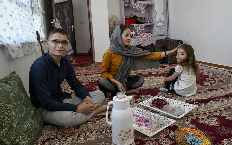 Mohammed Naiem Asadi, his wife Rahima, and their daughter Zainab, 5, share a meal in their hiding spot of six months before leaving Afghanistan for the U.S. on May 31, 2021. Asadi, an Afghan pilot, received permission to come to America last fall due to Taliban death threats, but that permission had been rescinded.