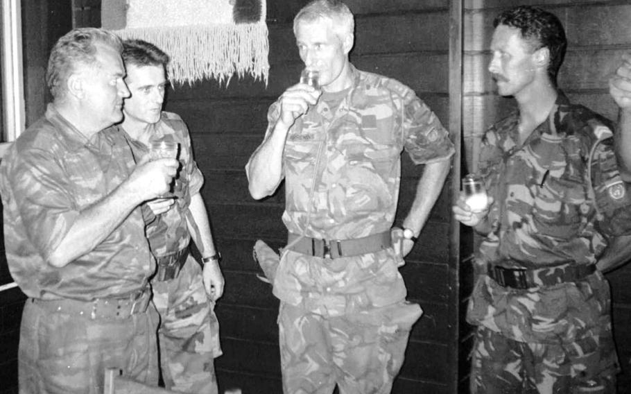 Bosnian Serb Gen. Ratko Mladic, left, drinks with Dutch U.N Commander Tom Karremans, second right, while others unidentified look on, in Potocari, some 3 miles north of Srebrenica,  Bosnia, on July 12, 1995. The Dutch government formally apologized Saturday, June 18, 2022 to soldiers who were sent as UN peacekeepers to defend the Bosnian enclave of Srebrenica with insufficient firepower and manpower to keep the peace.