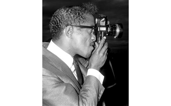 Tokyo, September 29, 1963:  While awaiting a helicopter flight to Tachikawa Air Base, where a crowd of 8,000 Air Force personnel gathered for his show, Sammy Davis Jr. tries out one of Japan's more popular products.