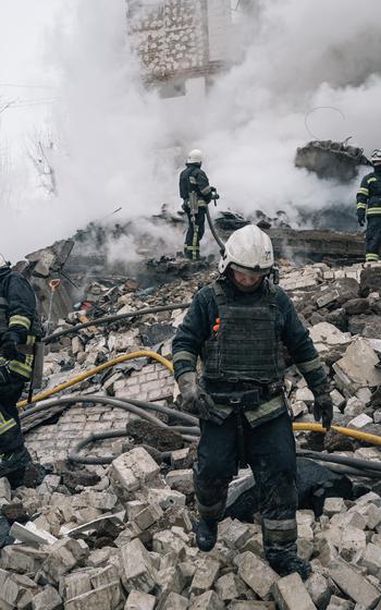 Rescuers search for survivors after a missile strike that destroyed a residential building in Kharkiv, Ukraine, on Tuesday. 