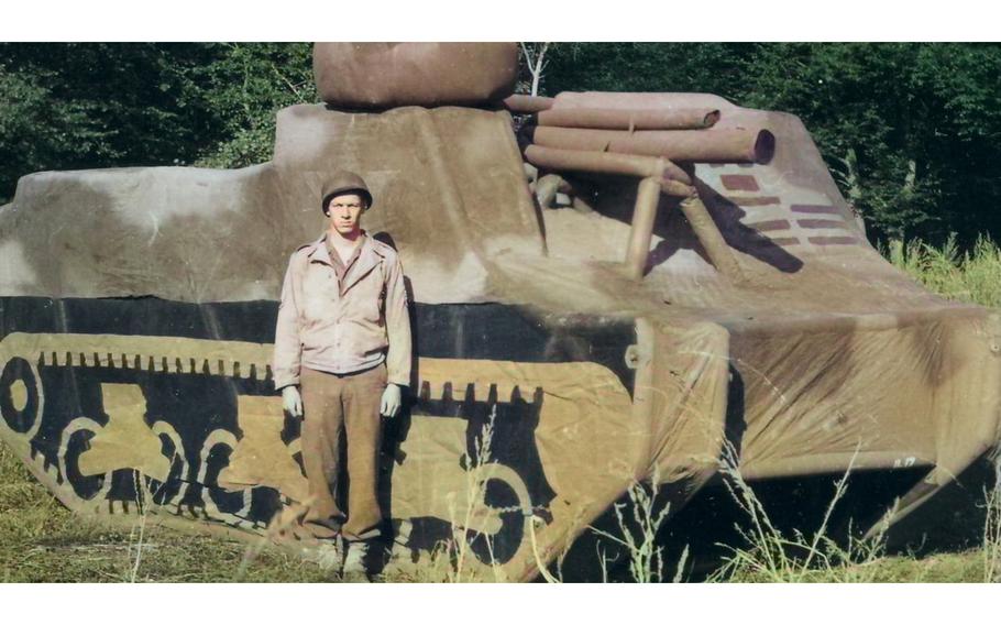 A “Ghost Army” soldier stands before an inflatable tank used to deceive enemies in World War II.