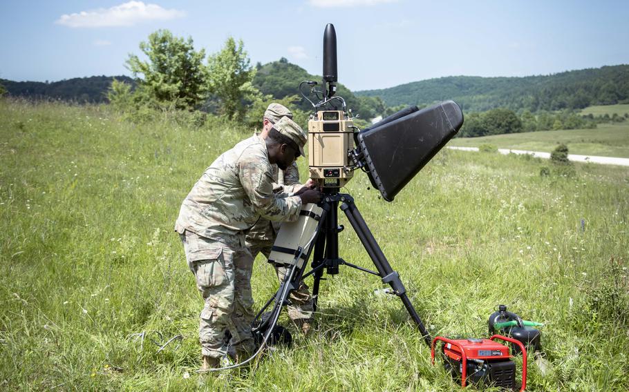 A uniformed troop sets up equipment.