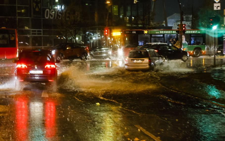 Cars make their way through a flooded road in Kiel, Germany, Thursday, Oct. 21, 2021. Germany is hit by heavy rain and storms.