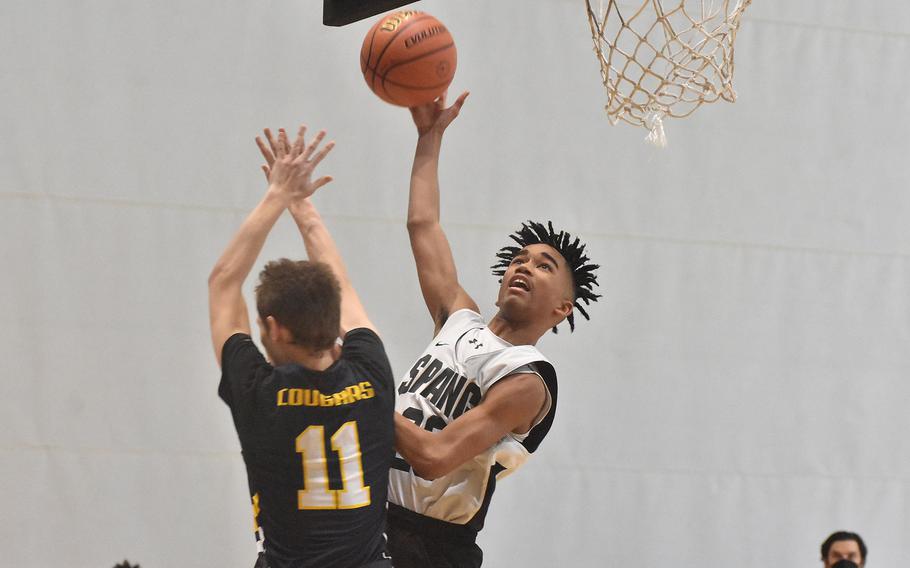 Spangdahlem's Robert Leggett lays it on over Ansbach's Brody Hoctor on Wednesday, Feb. 23, 2022, at the DODEA-Europe Division III basketball tournament at Ramstein Air Base, Germany.