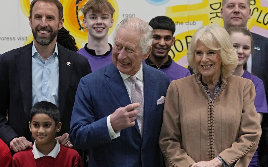 Britain’s King Charles III, center, Camilla, the Queen Consort, right, and Gareth Southgate, England football manager and Prince’s Trust ambassador, left, pose for a photograph with young people, staff and volunteers from the youth centre during a visit to the Norbrook Community Centre, Wythenshawe, in Manchester, England, Friday Jan. 20, 2023. 