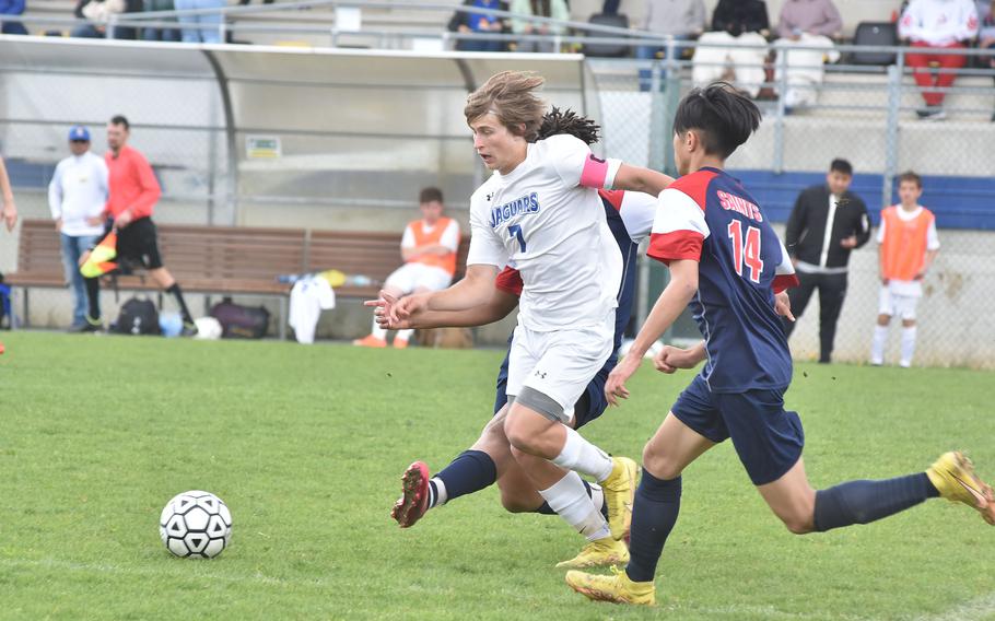 Sigonella's Tim Garcia manages to evade the tackle of Aviano's Terrance Johnson and the defense of Keoni Andres on Saturday, April 15, 2023.