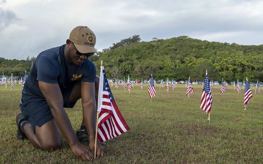 Petty Officer 2nd Class Seth Ampen, a hospital corpsman, helps place flags in Asan National Park on Guam, May 28, 2022, for a Memorial Day commemoration. 
