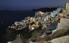 The blue lights of infinity pools and jacuzzis of luxurious hotels illuminate the village of Oia, on the island of Santorini, Greece, on Sept. 3, 2021. Oia is the ritziest of the villages carved into the rim of the island volcano that exploded into the sea 3,600 years ago. (AP Photo/Giovanna Dell’Orto)