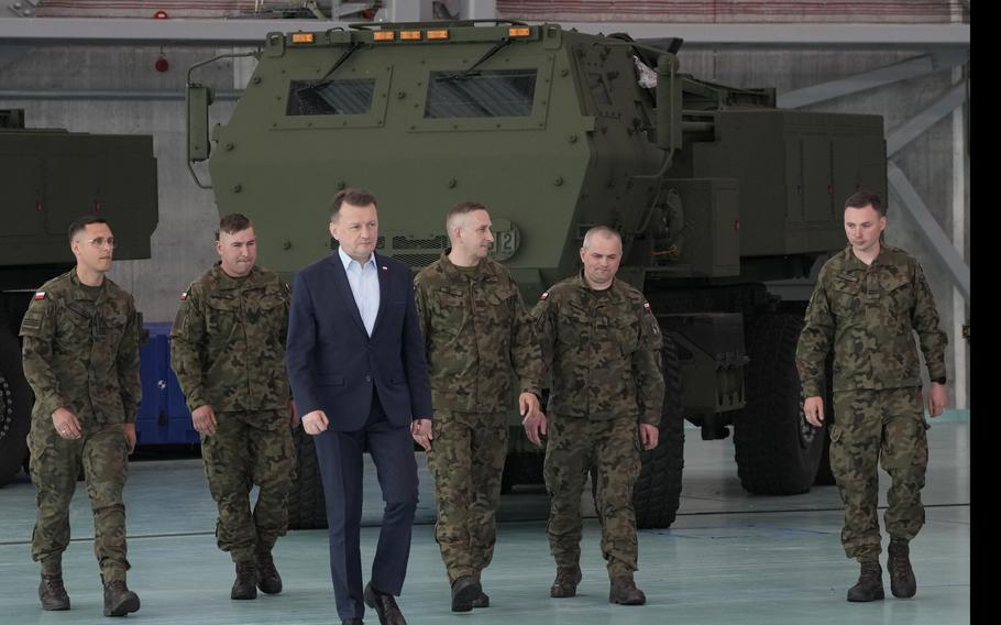 Defense Minister Mariusz Blaszczak, center, attends a ceremony after Poland received its first shipment of U.S.-made HIMARS rocket launchers, at an air base in Warsaw, Poland, on Monday, May 15, 2023. 