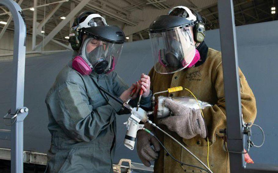 Staff Sgt. Chynna Patterson, a 28th Maintenance Group additive manufacturing spray technician, and David Darling, the 28th MXG additive manufacturing site manager, wait for the VRC Raptor Cold Spray machine to heat up at Ellsworth Air Force Base. The cold spray machine was developed by VRC Metal Systems.