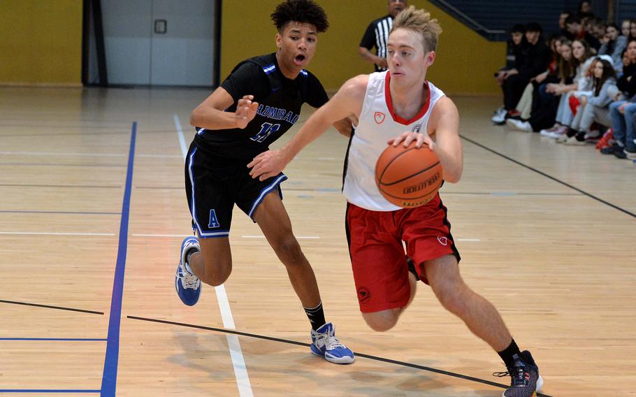 AOSR’s Parker Huber drives the ball up the court against Rota’s Jaylon Moody in a Division II semifinal at the DODEA-Europe basketball championships in Ramstein, Germany, Feb. 17, 2023. Rota won 59–51 to advance to the championship game against Naples.