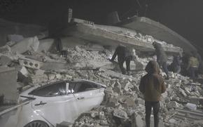 Syrian citizens search through the wreckage of a collapsed building, in Azmarin town, in Idlib province north Syria, Monday, Feb. 6, 2023. A powerful earthquake hit southeast Turkey and Syria early Monday, toppling buildings and sending panicked residents pouring outside in a cold winter night.