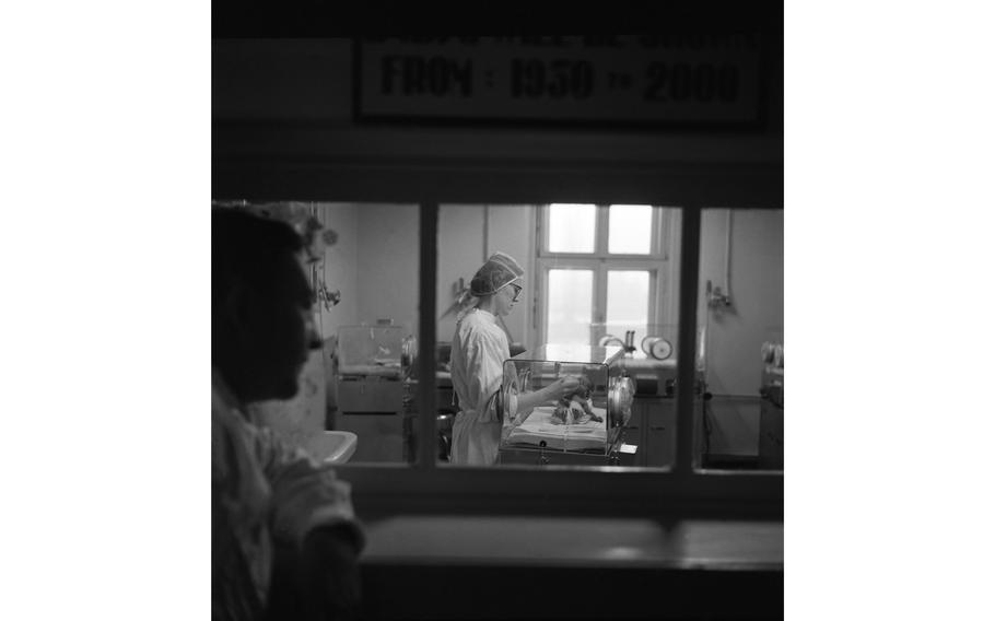 An unidentified nurse feeds a premature baby in its incubator at the 97th General Hospital Maternity Ward in Frankfurt, Germany.