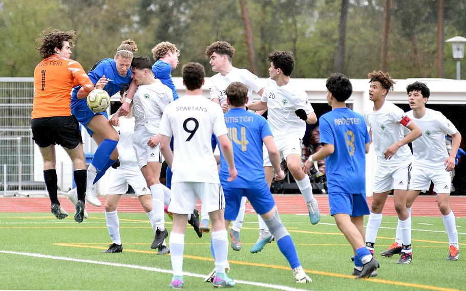 A mass of bodies, including Ramstein goalkeeper Brendan Stuever, left, fight over go after a corner kick during a soccer match between the Royals and SHAPE on April 5, 2024, at Ramstein High School on Ramstein Air Base, Germany.