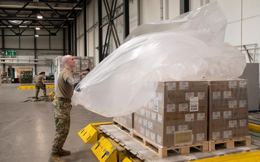 Airman 1st Class Ryan Koerner, a cargo processing specialist with the 721st Aerial Port Squadron at Ramstein Air Base, Germany, wraps baby formula in plastic on May 21, 2022, before it was flown to the United States to help ease a national shortage. 